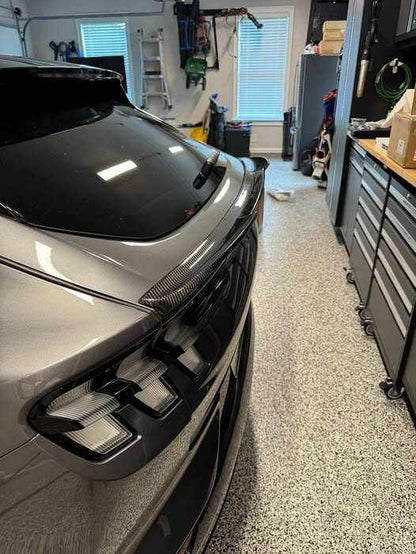 Spoiler V2 carbon fiber installed on rear of silver Mustang Mach-E in garage