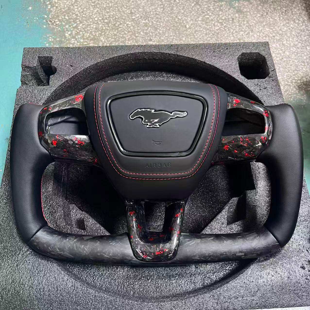 Custom Ford OEM Yoke steering wheel with Mustang logo, carbon fiber accents, and red stitching for Mach-E compatibility